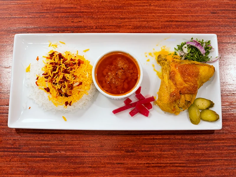 Zereshk polo ba morgh: saffron barberry rice with braised chicken and sauce