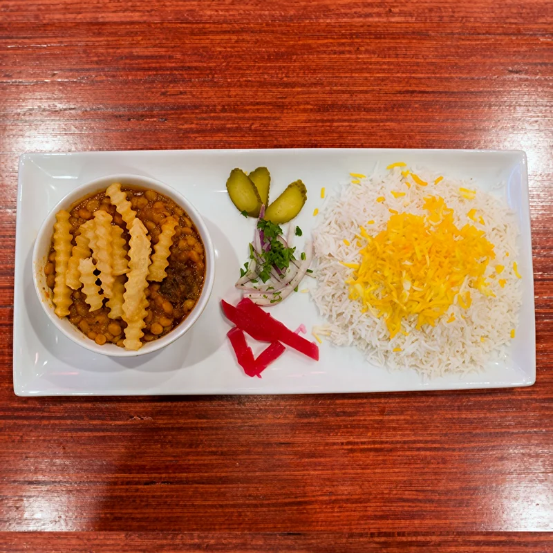 Khoresh gheymeh: split-pea and beef stew topped with fries, beside saffron rice
