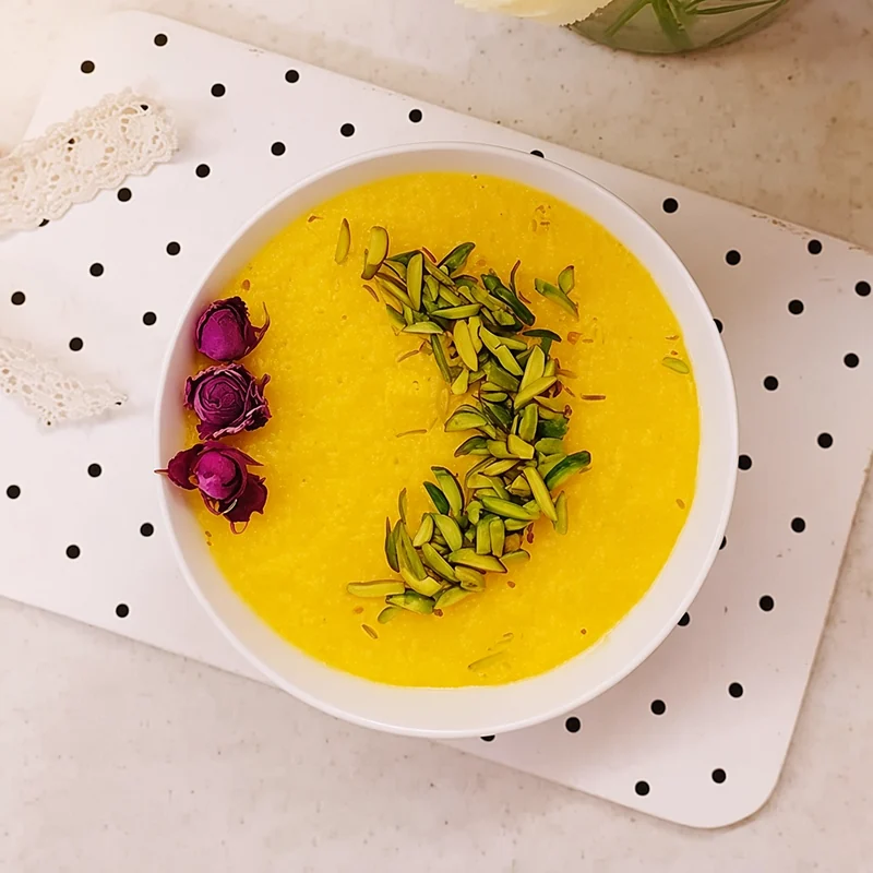 Saffron rice pudding topped with slivered pistachio and dried rosebuds