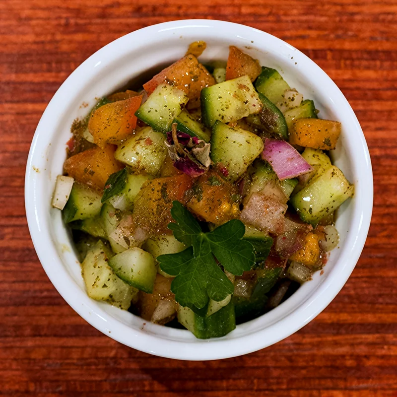 Shirazi salad of diced cucumber, tomato and onion with herbs in a white bowl